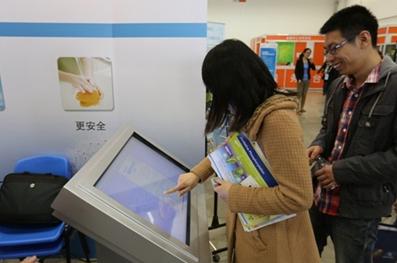 參觀者通過觸摸屏瀏覽產(chǎn)品信息